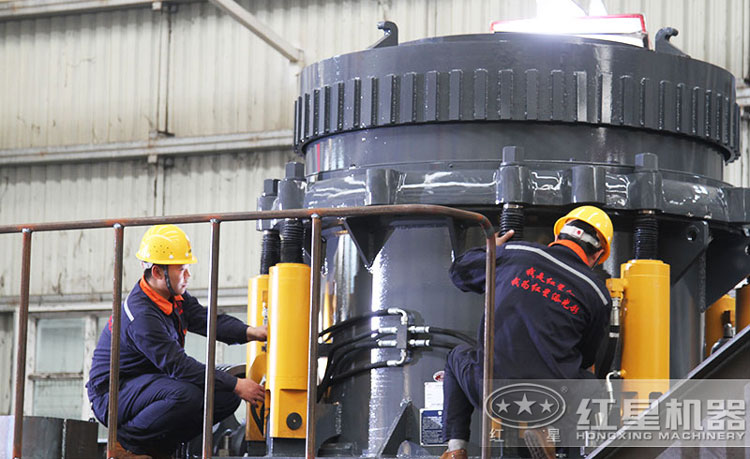 工作人員檢測圓錐破碎機(jī)，保障生產(chǎn)的設(shè)備都有高質(zhì)量